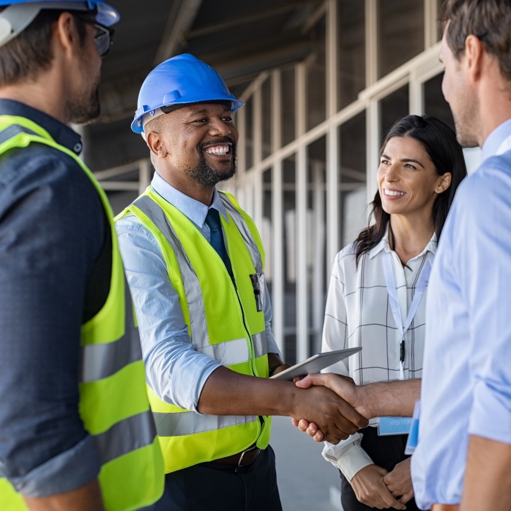 A project manager shaking hands with a client at a construction site